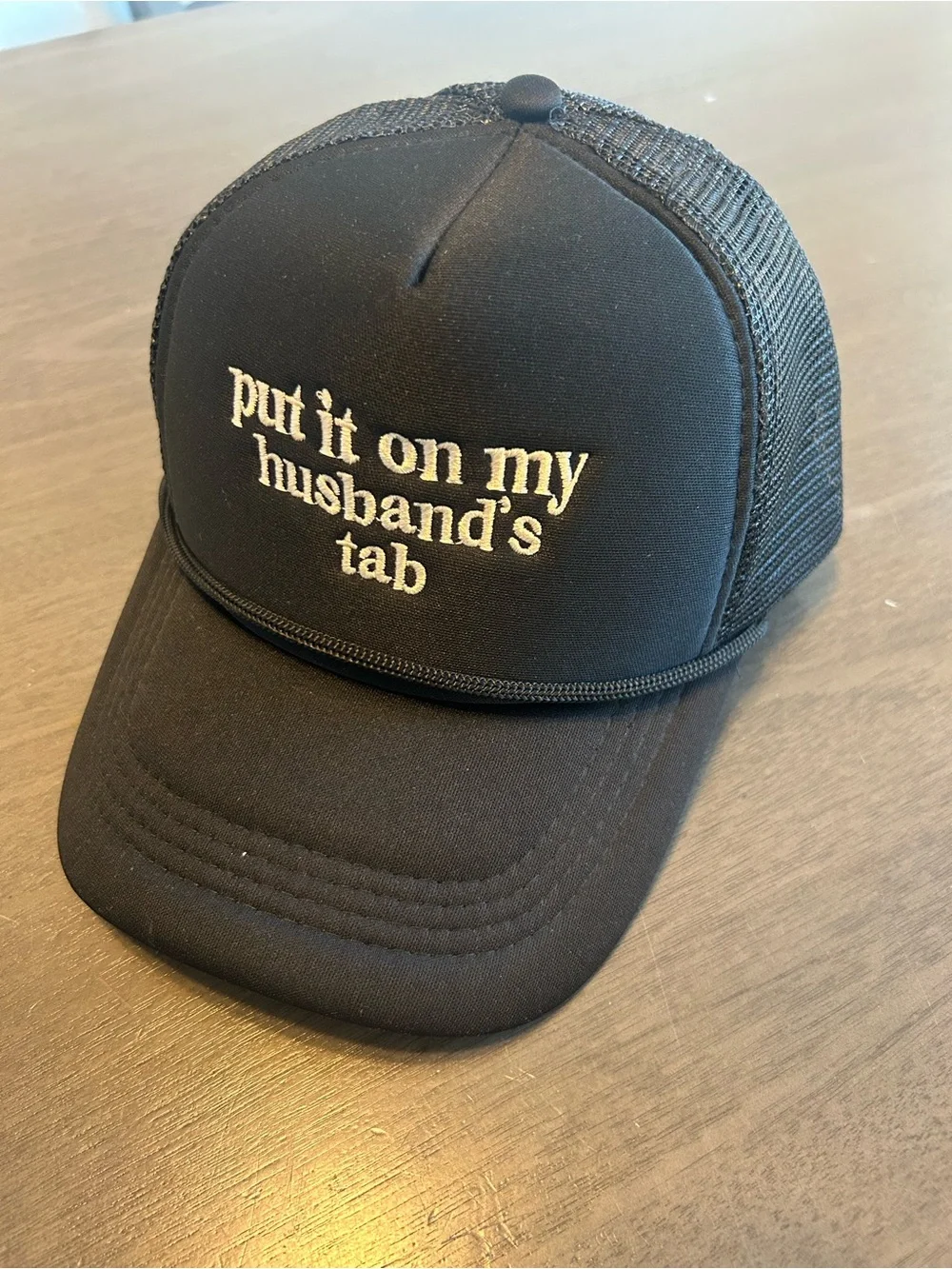 Black Trucker Cap with 'put it on my husband's tab' Embroidery
